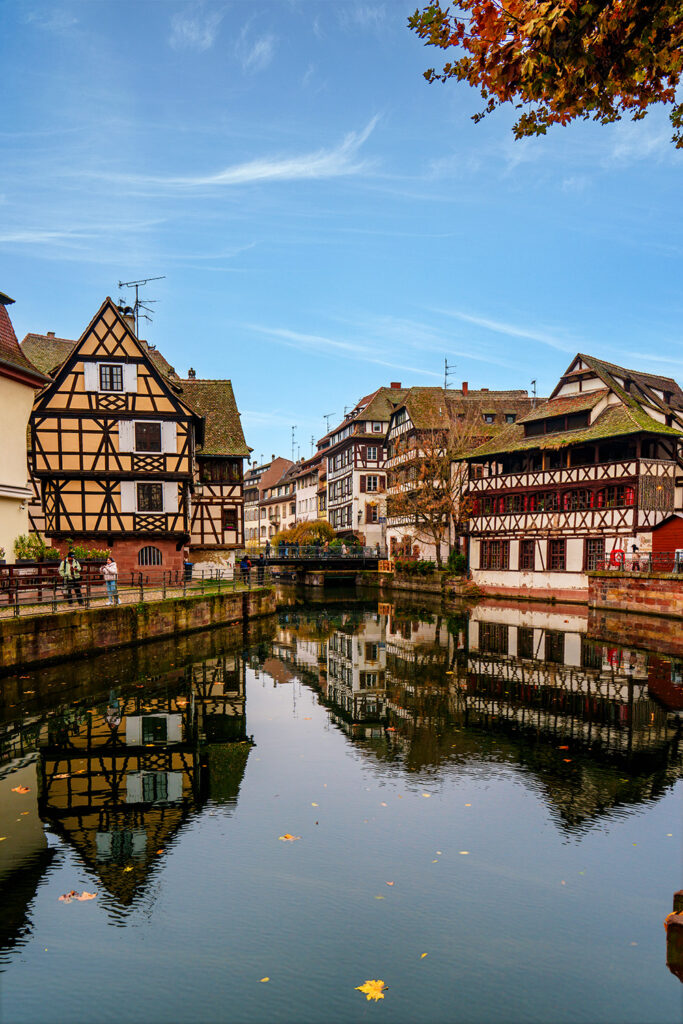 A picturesque scene of La Petite France in Strasbourg, featuring timber-framed houses, canals, and classic French travel aesthetics.