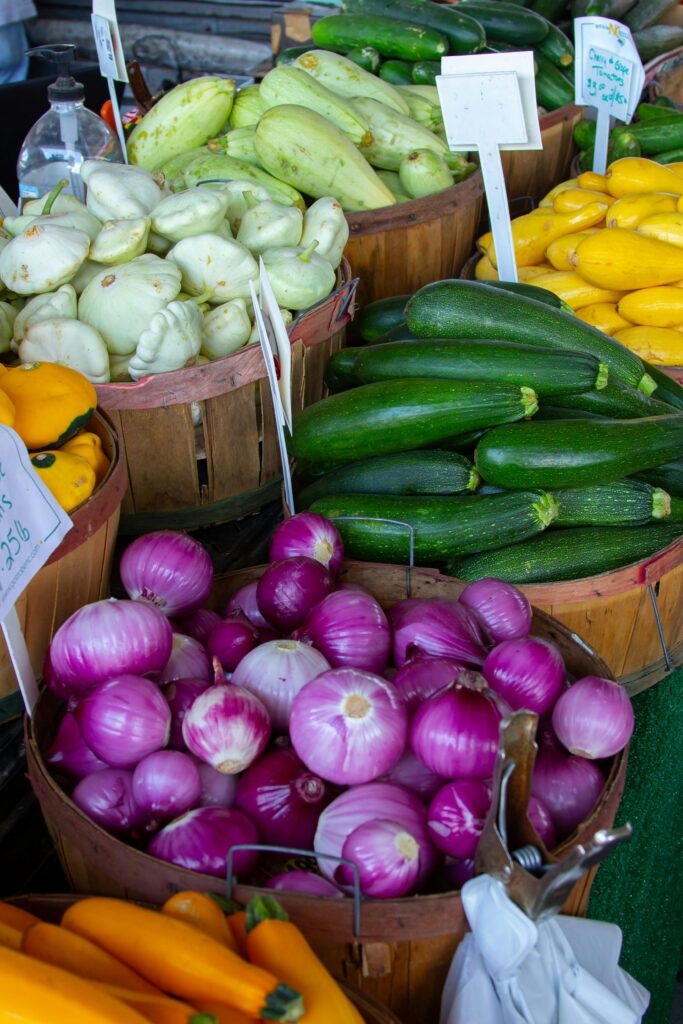 Colorful stalls at a farmers market offering low-cost, locally grown products ideal for travelers on a budget.